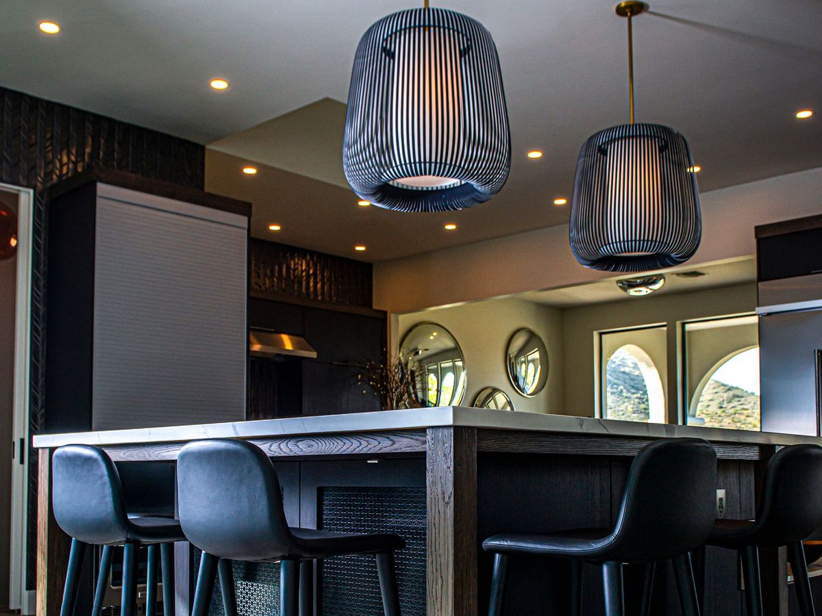 Woven pendant lights hanging over a dark bar counter