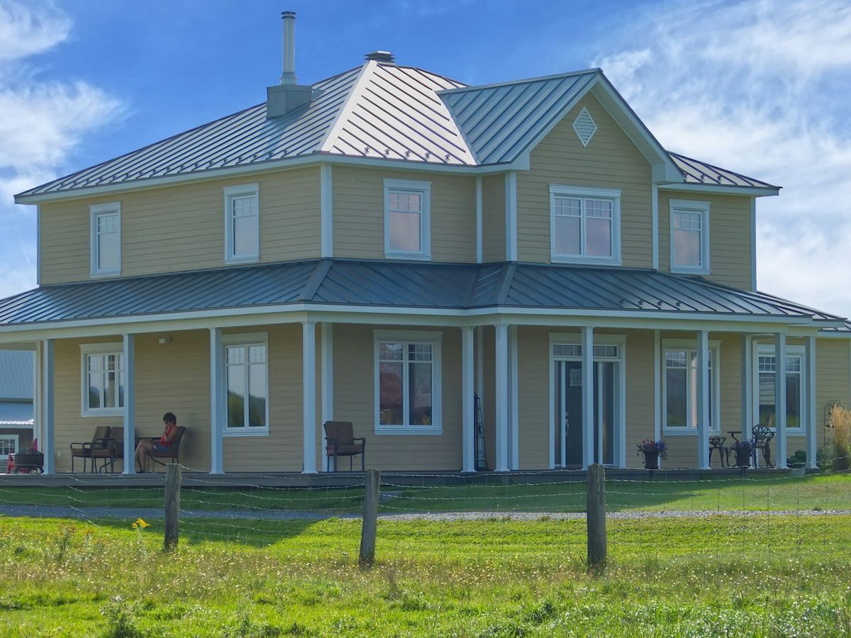 Two-story home with a metal roof and wraparound porch
